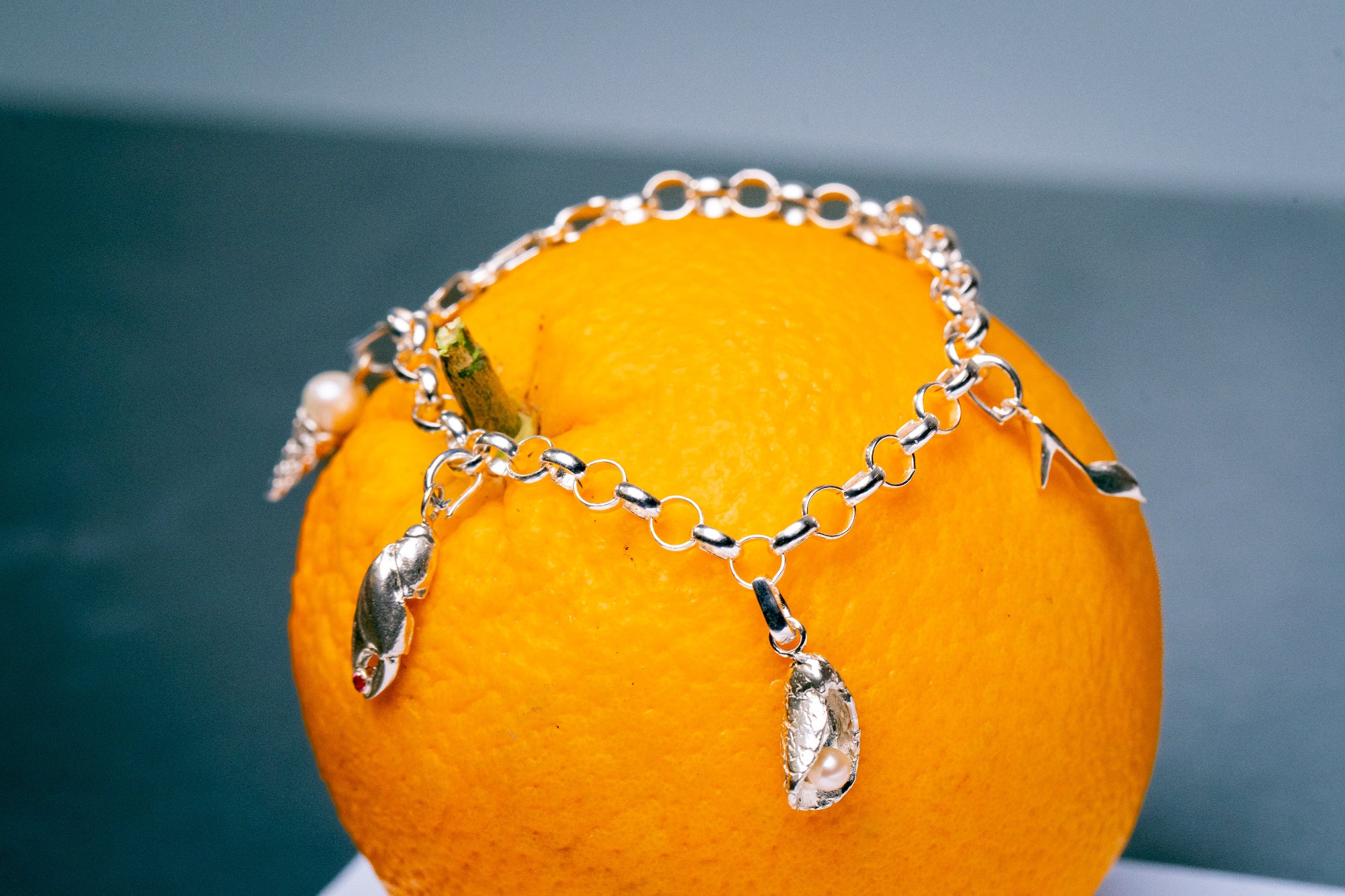 Close up van anker bedelarmband met verschillende bedels met parels en edelstenen 