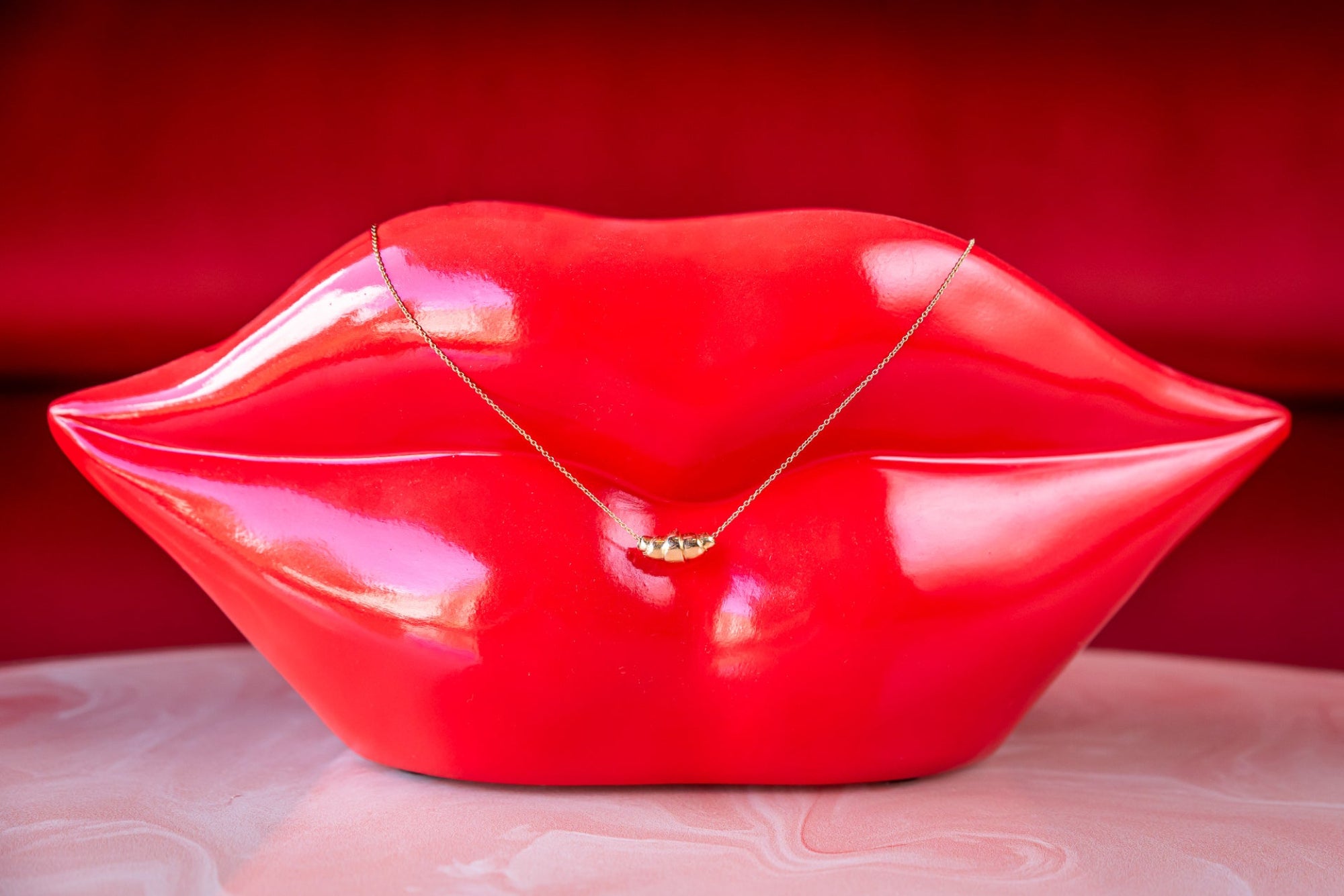 Collier met massief gouden croissant op rode lippen - Lara Boulangerie 
