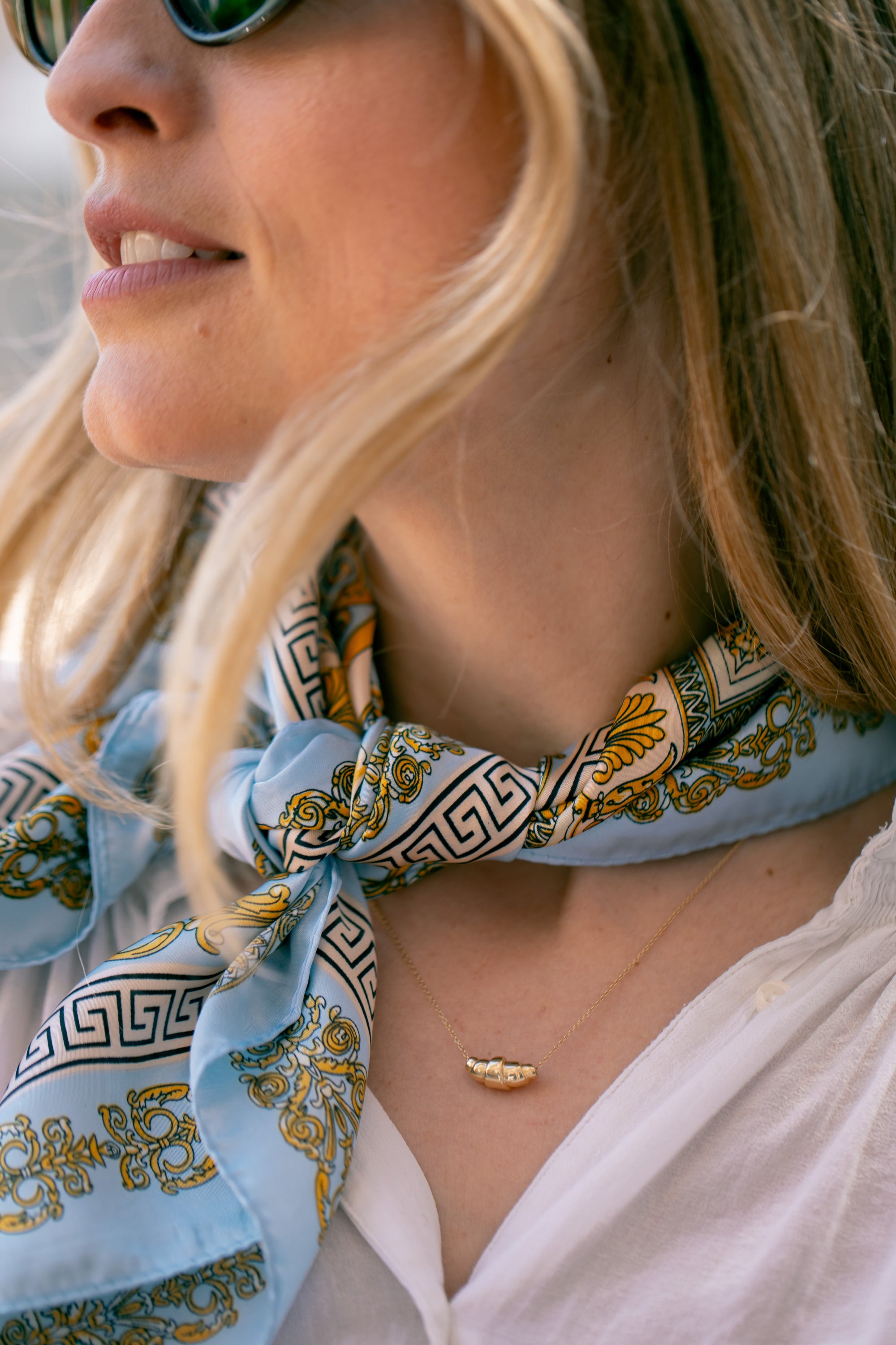 Woman wearing delicate gold croissant necklace - Le Petit Croissant by Lara Boulangerie 