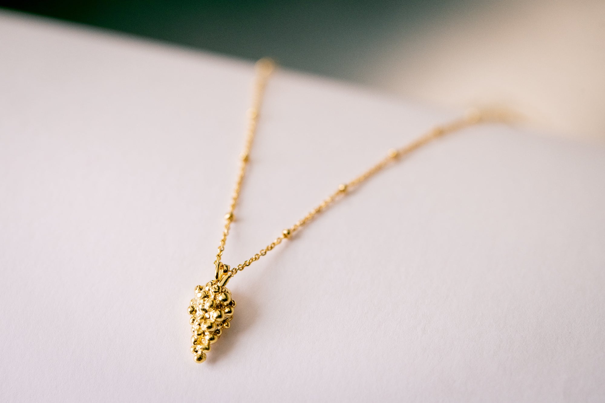 Close-up of gold pendant necklace La Grappe 