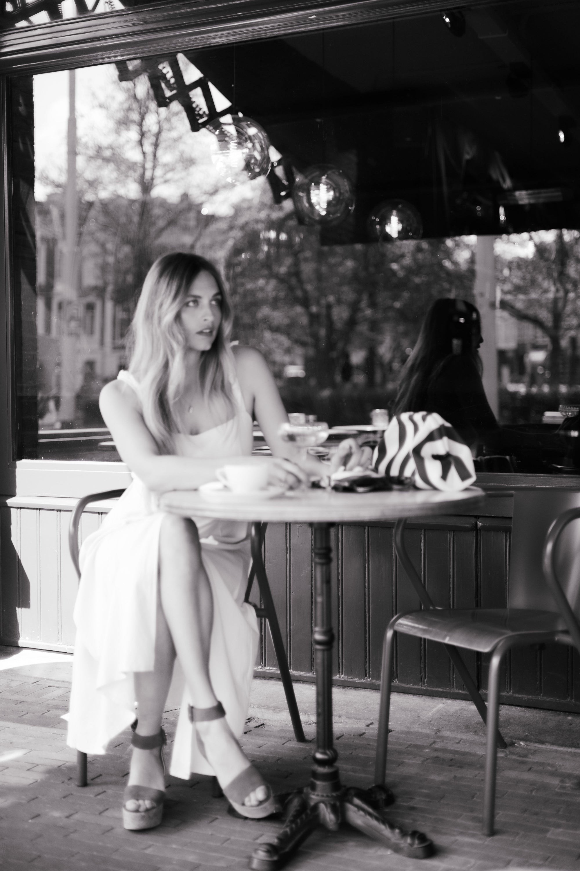 Woman sitting in a cafe wearing gold necklace - La Grappe by Lara Boulangerie