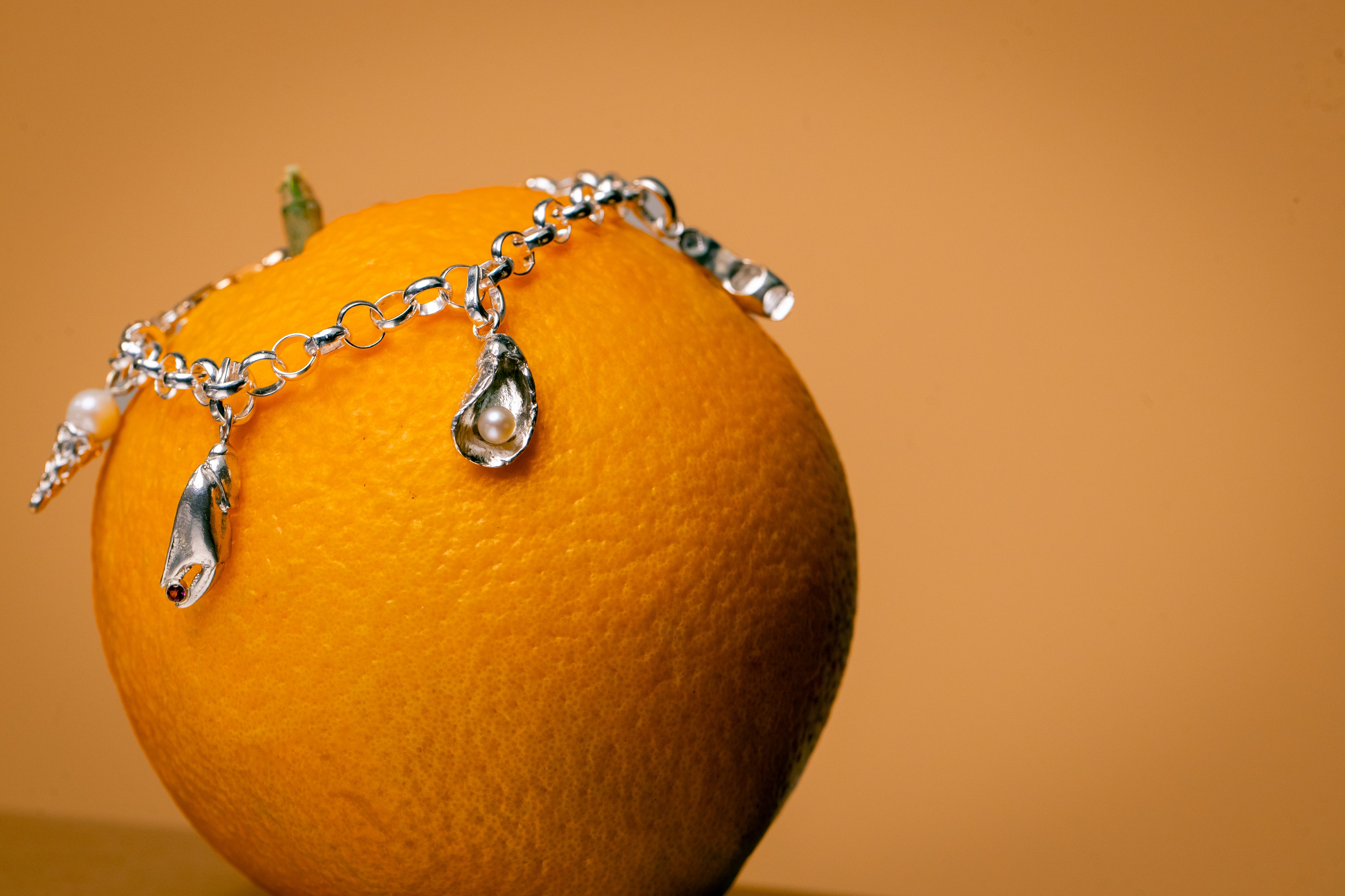 Close-up van bedelarmband met verschillende bedels met parels en edelstenen